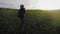 Young woman farmer in hat holding orange pumpkin in her hands the at field at sunset time . Pumpkin harvest. Agriculture