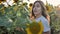 Young woman farmer posing with a harvest of large huge sunflowers in the field