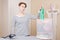 Young woman with fatigue looks at clean clothes in a laundry basket