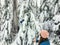 A young woman feeding whiskyjack and stellar jay birds out of her hand while snowshoeing along the Bowen Island Lookout trail on C