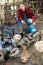 Young woman feeds domestic ducks on shore of man-made pond in the backyard of farm