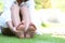 Young woman feeling pain in her foot on the grass, Health concept