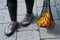 Young woman feet and black mesh bag full of oranges fruits