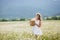 Young woman in a field of blooming daisies