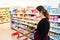 Young woman with filtering facepiece in a supermarket