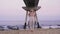 Young woman finishes sun salutation at the beach. Yoga exercise near the ocean.