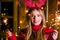 Young woman firing festive sparkles and celebrating Christmas sweater in a wooden log cabin