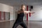 Young woman fitness instructor in black stylish clothes shows how to keep balance standing in the gym. Slim beautiful girl