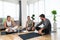 Young woman fitness and yoga instructor helping couple in their home for workout exercises. Female coach working with clients