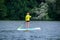 A young woman floats on a SUP board along a large river. Swim on the board for amazing outdoor activities