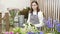 Young woman florist checking and selecting the best flowers for a bouquet in a workshop or flower shop.