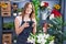 Young woman florist make photo to flowers at florist shop