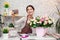 Young woman florist at work. Business woman takes a selfie with a bouquet, happy smiling woman making bunch at flower