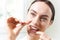 Young Woman Flossing Teeth In Bathroom