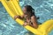 Young woman on a flotation device swimming in a swimming pool