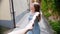 A young woman follows her boyfriend by a hand through a street in Italy and looking around