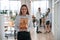 Young woman in formal clothes is standing in the office with bunch of eco boxes in hands