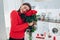 Young woman found bouquet of roses, wine and gift box on kitchen. Happy girl hugging flowers. Valentines day