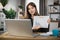 Young woman freelance showing graphs and chart while sitting at table.