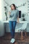 Young woman freelancer indoors home office concept casual style browsing smartphone