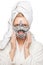 Young woman with fresh healthy skin and hairs aplying alginate mask and smiling. Cosmetology, beauty and spa. White