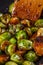 Young woman fries Brussels sprouts on a frying pan