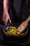 Young woman fries Brussels sprouts on a frying pan