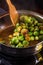 Young woman fries Brussels sprouts on a frying pan