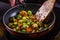 Young woman fries Brussels sprouts on a frying pan