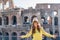 Young woman in front of colosseum in rome, italy