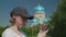 Young woman frowns, shakes head, swipes on smartphone, church in background