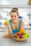 Young woman with fruits plate eating apple