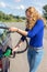 Young woman fueling car tank with gasoline