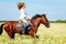 Young woman galloping horseback in flowery meadow