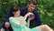 A young woman gently feeds a man with a strawberry.