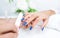 Young woman getting manicure in beauty salon. Close-up, color classic blue