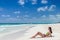 Young woman getting sun at tropical white sandy beach