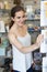 Young Woman In Gift Shop Choosing Greetings Card