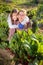 Young woman with a girl child is harvesting beets from the garden bed