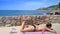 Young woman, girl, female in a bathing suit is sunbathing her naked back close to the sea