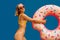 Young Woman Girl Posing With Donut-Shaped Swim Inflatable Ring Isolated On Blue Background.