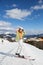 young woman, a girl - a teenager on skis stands on top of a snow-covered mountain slope on a cold winter sunny day