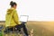 Young woman girl traveler freelancer in yellow hoodie with opened laptop with white screen on the beautiful view background