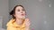 young woman girl in yellow making soap bubbles on grey background. happy, exited. slow motion