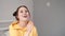 young woman girl in yellow making soap bubbles on grey background. happy, exited. slow motion