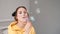 young woman girl in yellow making soap bubbles on grey background. happy, exited. slow motion