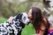 Young woman gives her Dalmatian dog a kiss