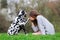 Young woman gives her Dalmatian dog a kiss on the paw