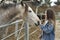 Young woman giving affection to some horses.