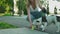 Young woman giving water to dog in park.